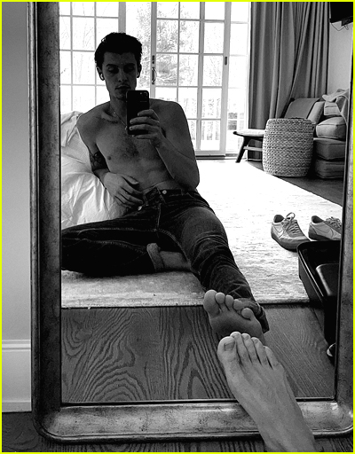 Shawn Mendes sits on the floor and takes a shirtless photo in the mirror