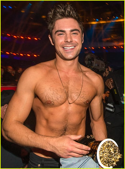 Zac Efron goes shirtless while holding his MTV Award popcorn trophy