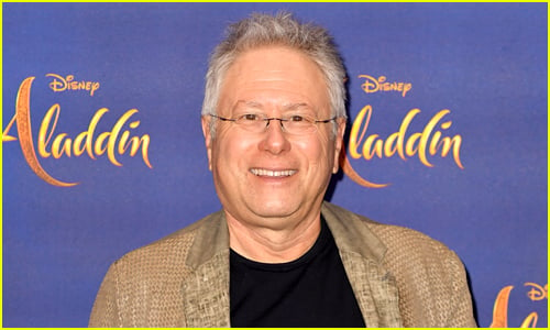 Alan Menken smiles while at an event for Aladdin