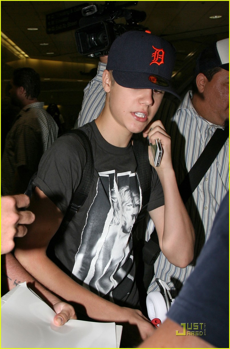 Justin Bieber dons a hoodie and baseball cap with skinny jeans at LAX