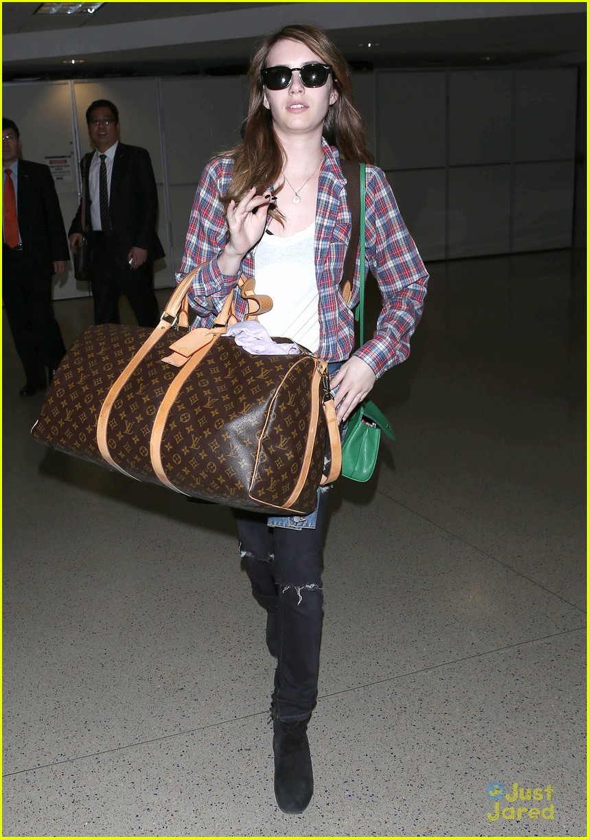 Emma Roberts carefully inspects her Luitton luggage as she arrives at  airport
