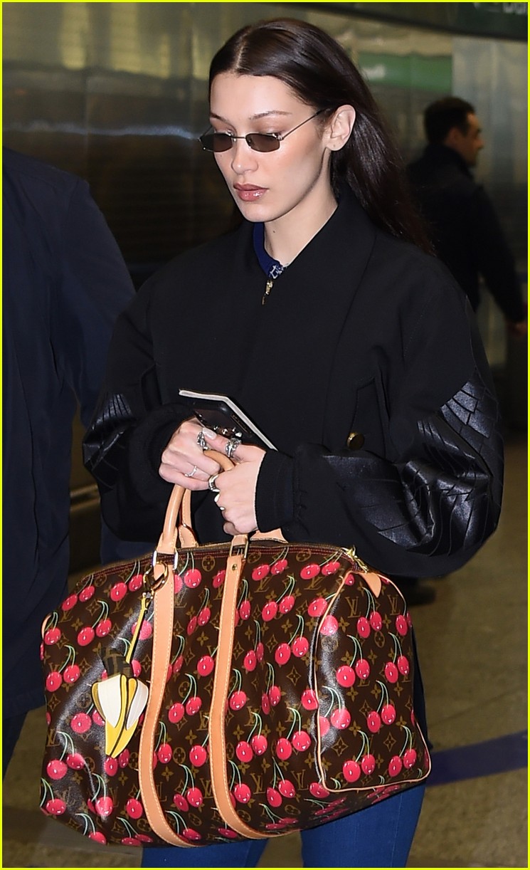 Bella Hadid arrives in Paris clutching onto a $12,000 Louis Vuitton cherry  print holdall