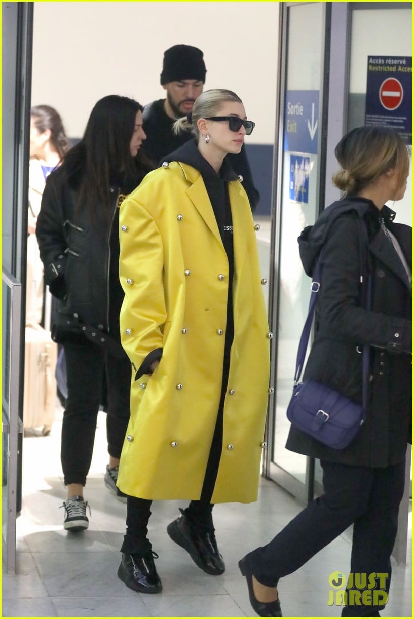 hailey bieber sports bright yellow coat for flight to paris 03