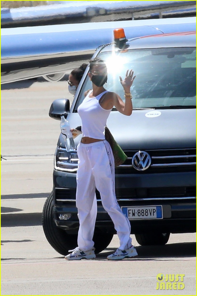 Full Sized Photo of hailey bieber bella hadid fly home from sardinia 29