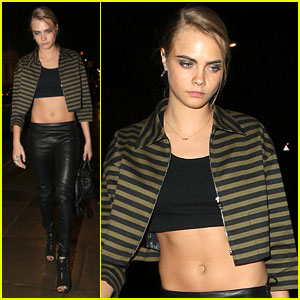 Cara Delevingne flaunts her abs as she lifts her t-shirt ahead of