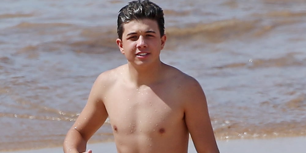 Bradley Steven Perry and one of his sisters head back in from the water to ...